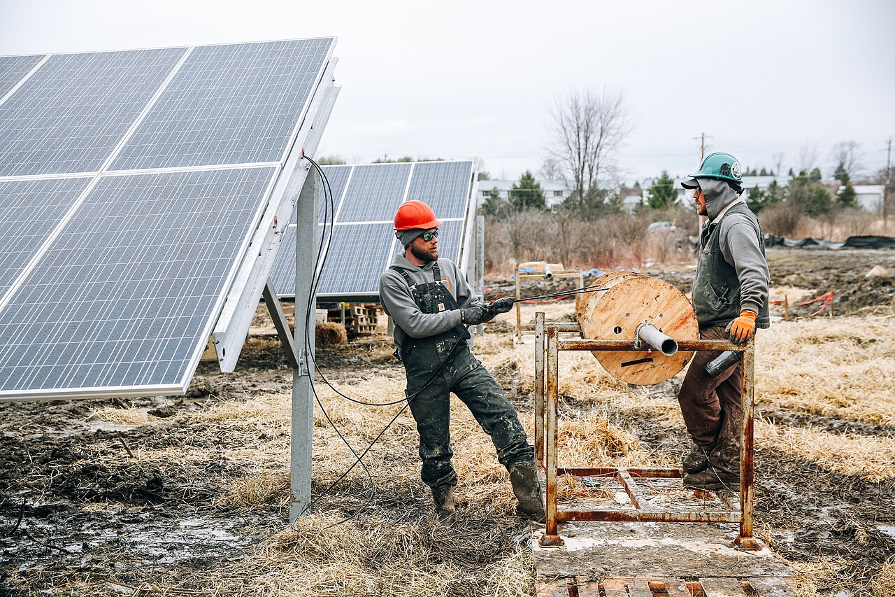 Technicians running cable at a large solar installation